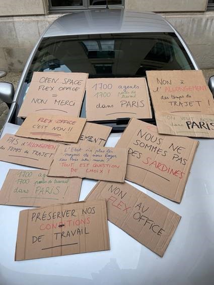 Voiture flotte ministère recouverte par des cartons de slogans